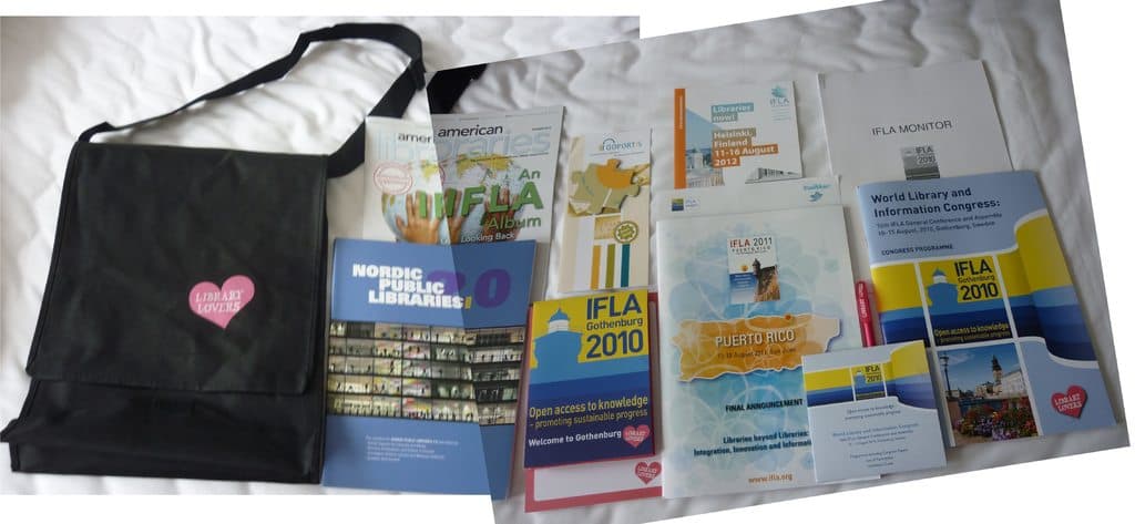 Eine Tasche mit den Worten 'Bibliotheksliebhaber' und einigen Büchern auf einem Bett.