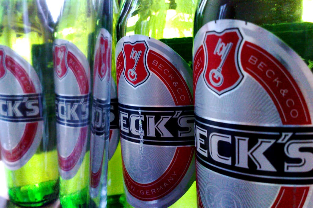 Ein grüner Bierflaschenhals mit einem daran befestigten Etikett.