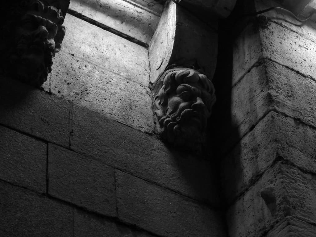 Skulpturen vor einer Zementwand in einem Gebäude ausgestellt.