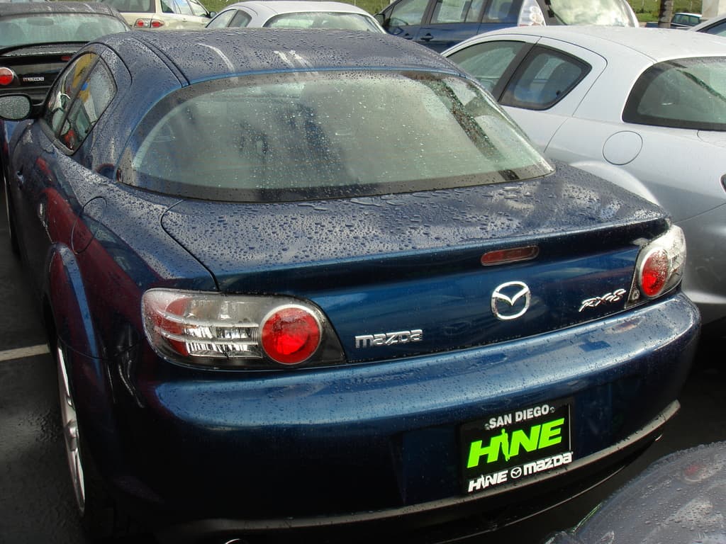 Mehrere Autos auf einer Straße mit einem Schild am Boden.