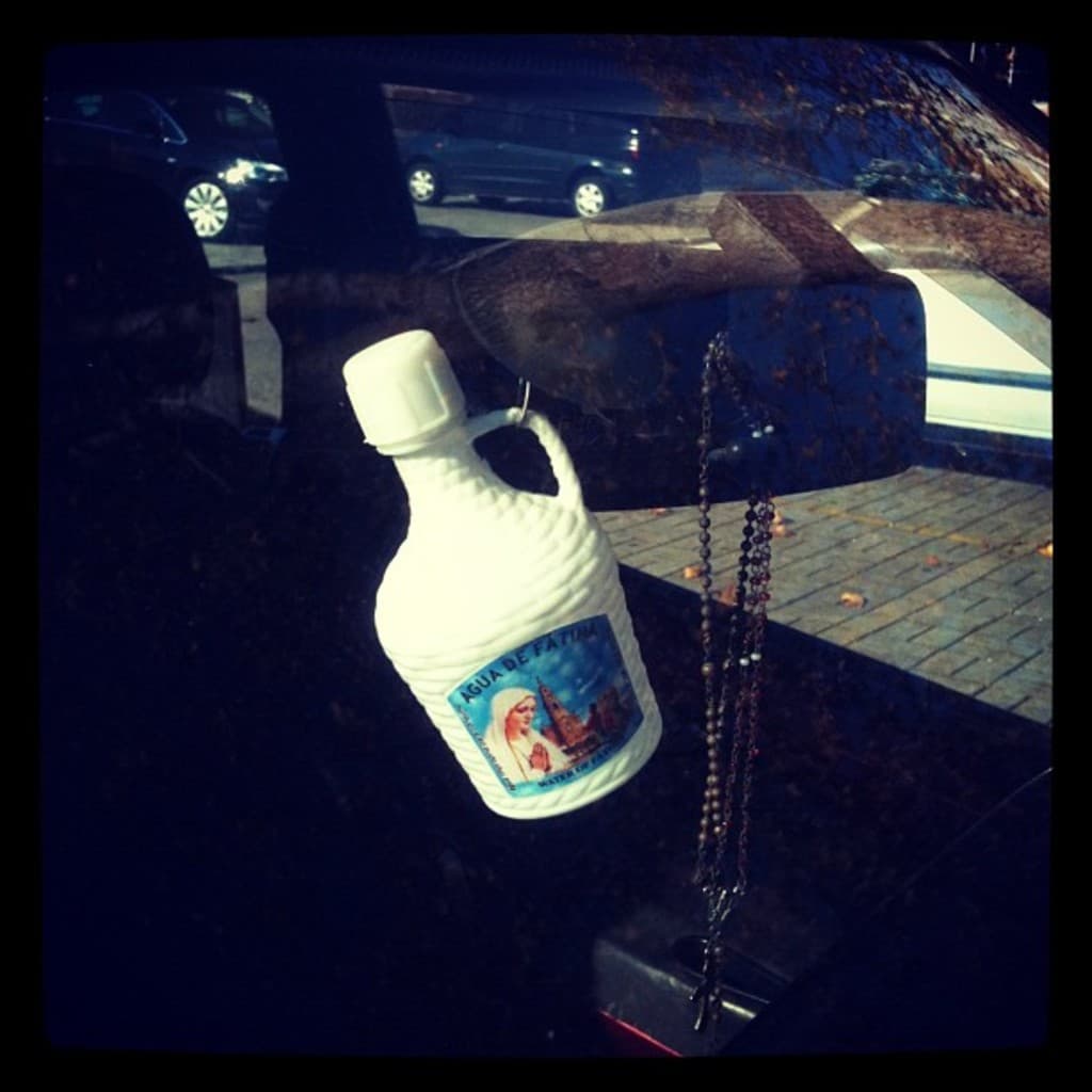 Ein Auto steht mit einer Kette und einer Flasche in der Nähe auf der Straße geparkt.