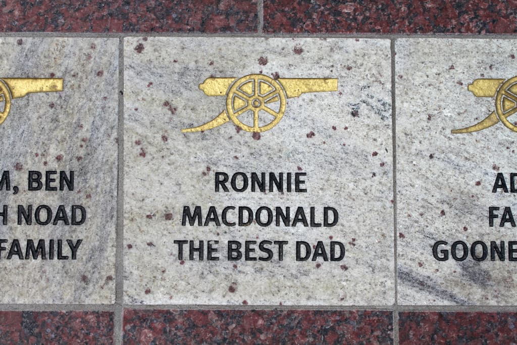 Ein historisches Schild mit Symbolen und Text in der Bildmitte.