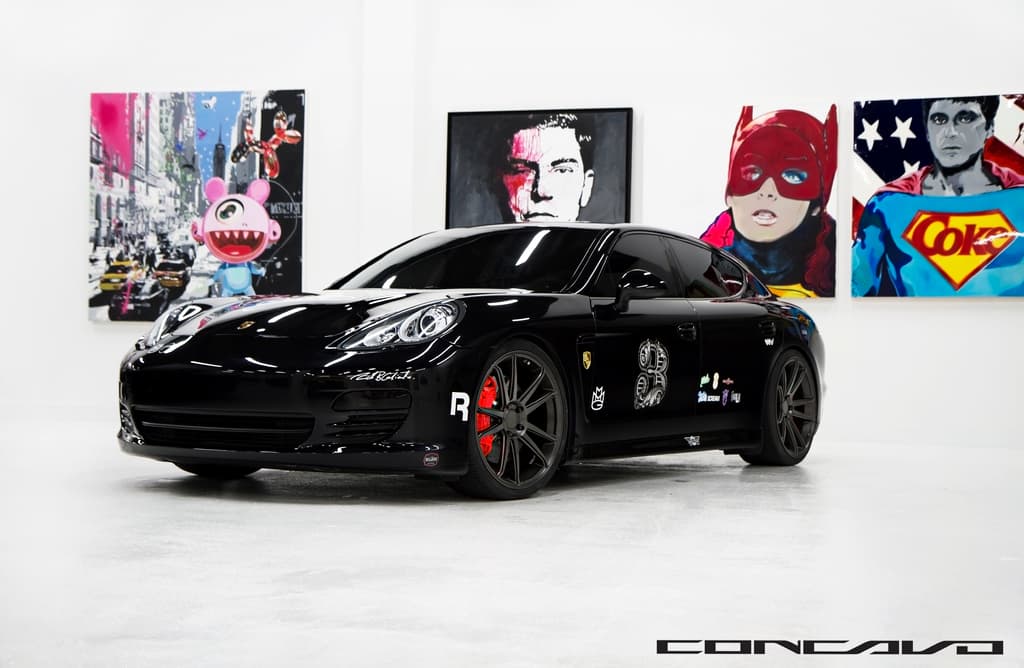 Ein schwarzer Nissan-Sportwagen steht vor Cartoons, mit einer kleinen Inschrift am unteren Bildrand.