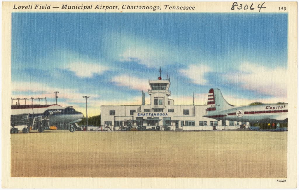 Ein Gebäude mit Antennen auf dem Dach, flankiert von Flugzeugen auf der rechten und linken Seite.