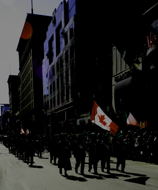 Der Himmel ist oben, Gebäude mit Text sind rechts, eine Straße ist unten mit Gruppen von Menschen, die stehen und marschieren, einige halten Fahnen.