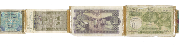 Ein altes Buch mit verschiedenen Nennwerten alter deutscher Banknoten darauf gestapelt.