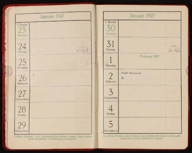 Ein offenes deutsches Tagebuch aus dem Jahr 1927 mit einem Kalender darauf, vor einem dunklen Hintergrund.