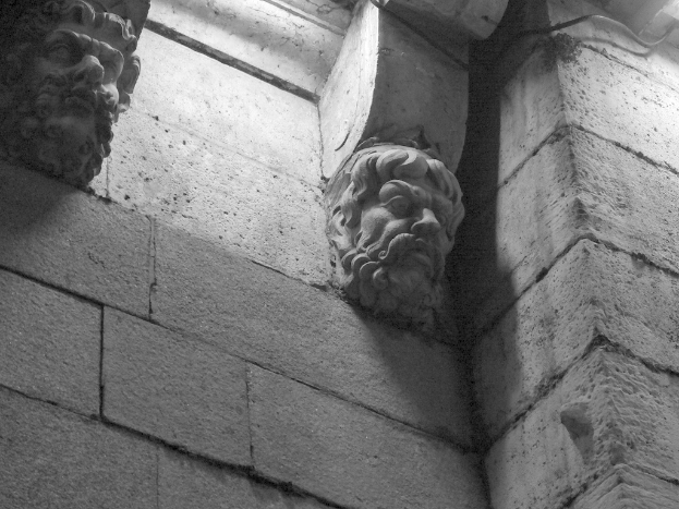 Skulpturen vor einer Zementwand in einem Gebäude ausgestellt.