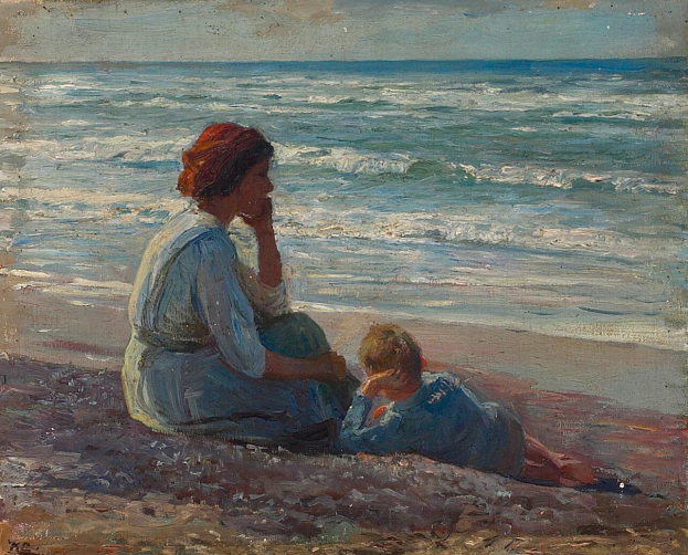 Eine Mutter in einem hellen Kleid und ein junger Junge sitzen am Strand und schauen beim Sonnenuntergang über das Meer zu, während die Wellen an den Strand rollen.