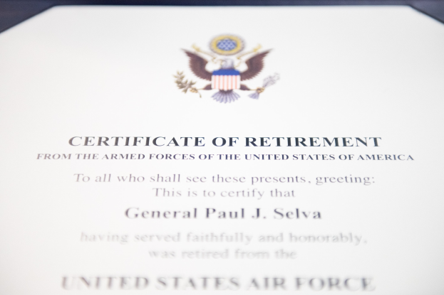 Rahmenurkunde für den Ruhestand der United States Air Force mit blauem Rand, zentralem Stern in einem Lorbeerkranz und einem 'Ruhestand'-Banner auf einem Schild-Logo, alles in schwarzer Schrift.