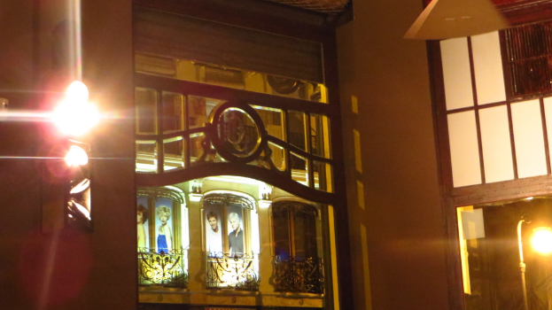 Ein Gebäude mit Gittern, Plakaten und Lichtern drumherum.