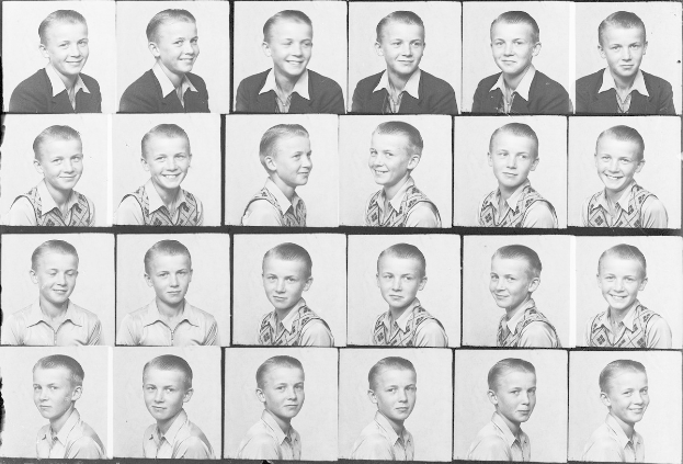 Ein Schwarz-Weiß-Foto eines strahlenden jungen Jungen mit ordentlich gekämmtem Haar, hellen Augen und einem fröhlichen Gesichtsausdruck.