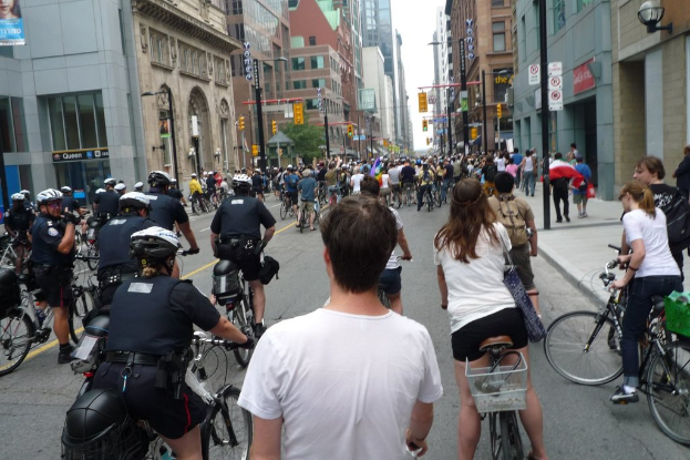 Geb√§ude säumen eine Straße, auf der ein paar Menschen Fahrräder fahren.