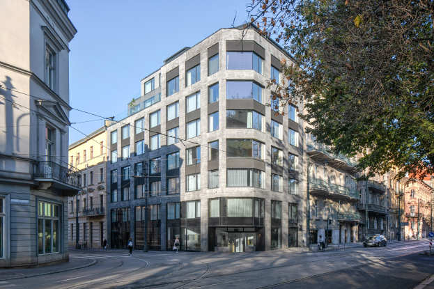 Großes modernes Bürogebäude mit zahlreichen Fenstern, umgeben von Straßeninfrastruktur, Fahrzeugen, Fußgängern, Bäumen und einem bewölkten Himmel als neue Firmenzentrale.