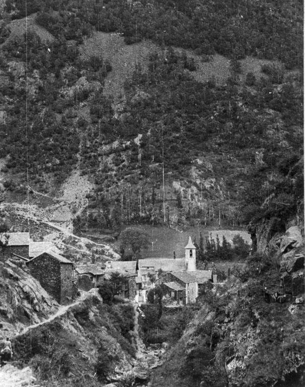 Schwarz-weiß-Foto eines kleinen Bergdorfes umgeben von Bäumen und Häusern.