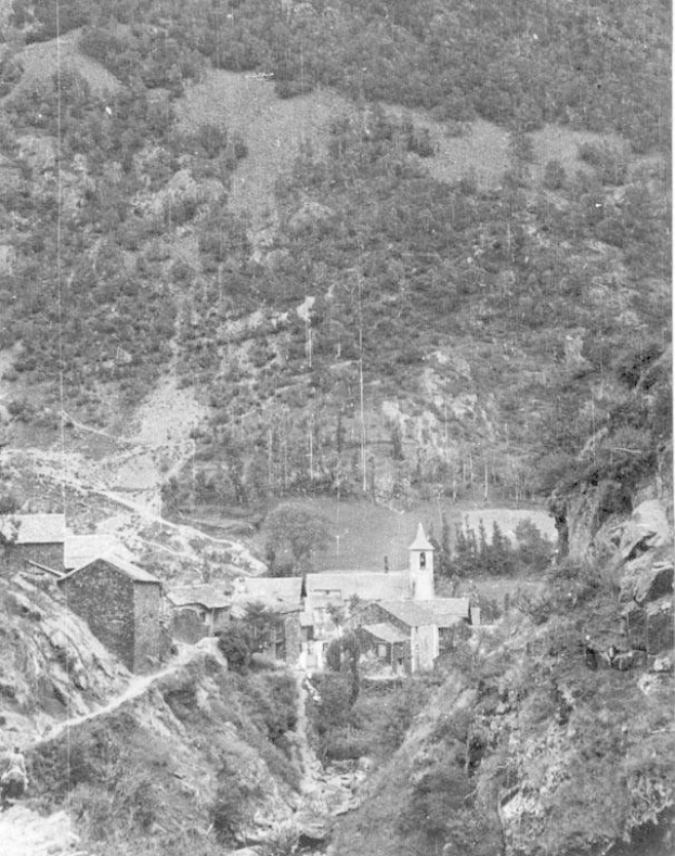 Schwarz-weiß-Foto eines kleinen Bergdorfes umgeben von Bäumen und Häusern.