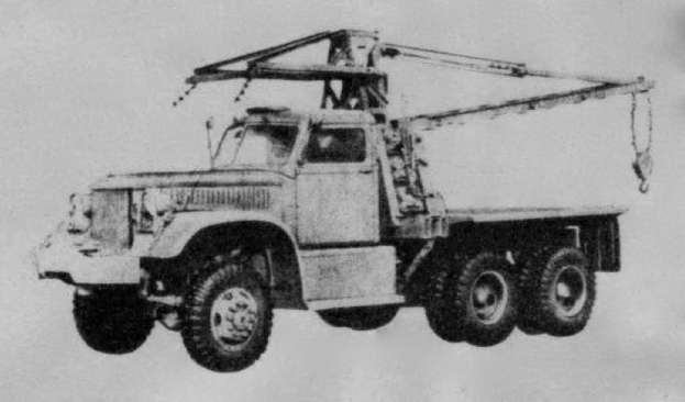 Schwarzes und weißes Foto eines großen, vierrädrigen Lkw mit einem Kran auf dem Rücken und einem flachen Anhänger, der angeblich das erste Schwerlastfahrzeug der Welt ist.