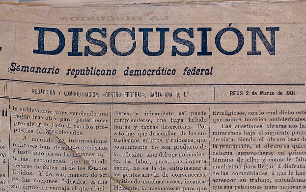 Ein gelblich, leicht zerknittertes Zeitungsblatt mit der Aufschrift "Diskussion" in schwarzer Tinte, das die Überschrift "Semanario Repúblicano Democrático Federal" trägt.