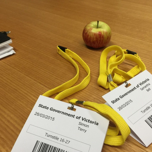 Ein Tisch mit zwei Ausweisen, einem Apfel und einem schwarzen Gegenstand.