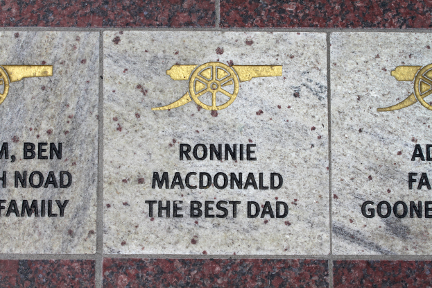 Ein historisches Schild mit Symbolen und Text in der Bildmitte.