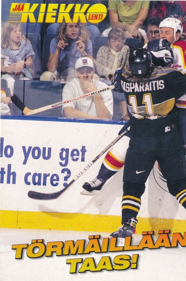 Ein Hockey-Spieler in Aktion auf dem Eis, der einen Helm trägt und einen Hockey-Schläger hält, mit ein paar Menschen, die im Hintergrund auf Stühlen sitzen, und Text am unteren Rand des Bildes.