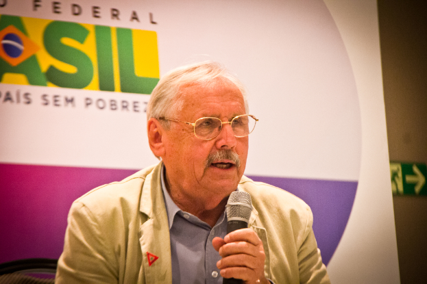 Eine Person mit einem Mikrofon vor einem Banner mit der Aufschrift 'Bundes'