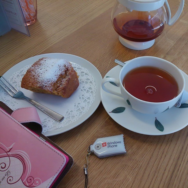 Ein Tisch mit einer Geldbörse, Schlüsselanhänger, Tasse, zwei Tellern, einer Gabel, einem Lebensmittel, einer Suppenschale und einem Löffel.