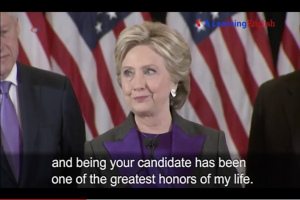 Hillary Clinton und Joe Biden stehen Seite an Seite in schwarzen Blazern, weißen Hemden und lila Krawatten, mit einer Flagge dahinter und einem Zitat von Hillary Clinton unten.