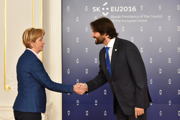Bundeskanzlerin Angela Merkel und Joachim Gauck schütteln sich die Hände bei einem EU-Gipfeltreffen, beide lächeln.