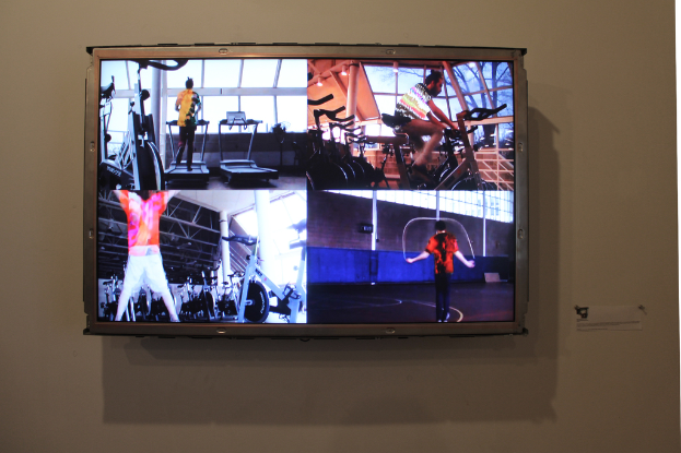 Ein Fernseher an der Wand, der Menschen beim Sport zeigt.