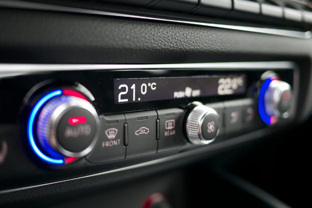 Eine Steuerung mit mehreren Knöpfen, Reglern und Leuchten, mit Text in der Mitte.