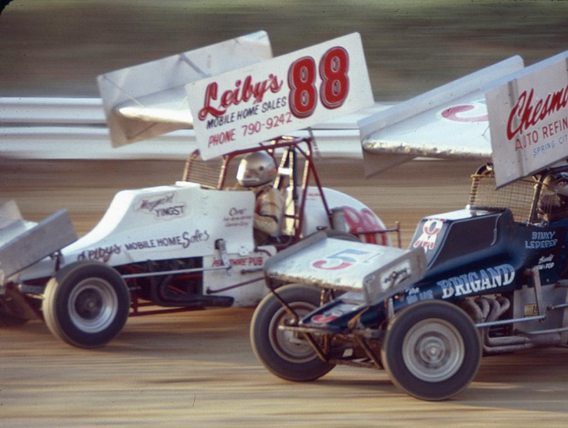 Mehrere Autos fahren auf einer Straße mit einer Sicherheitsschranke, mit einem unscharfen Hintergrund.