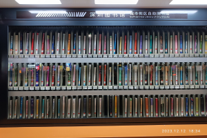 Eine gut beleuchtete Bibliothek mit Reihen von Bücherregalen, einem sichtbaren Informationsschild und einem Wasserzeichen unten, das an eine Selbstbedienungsbibliothek der Stadtblocks erinnert.