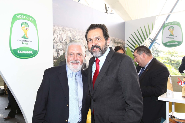 Eine Gruppe von Menschen, die mit einigen lächelnden Gesichtern und einem FIFA-WM-Plakat im Hintergrund steht.