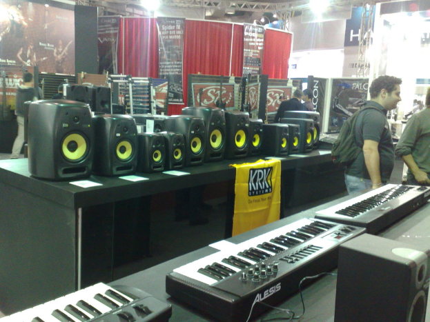 Menschen in einem Raum mit Lautsprechern auf einem Tisch und Casinos im Hintergrund.